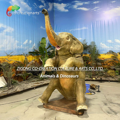Statue réaliste d'éléphant africain animatronique aspergeant de l'eau dans un décor de safari